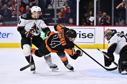 Feb 12, 2024; Philadelphia, Pennsylvania, USA; Philadelphia Flyers right wing Owen Tippett (74) falls after a hit from Arizona Coyotes defenseman Travis Dermott (33) in the first period at Wells Fargo Center. Mandatory Credit: Kyle Ross-USA TODAY Sports