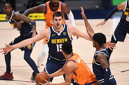 Jan 1, 2021; Denver, Colorado, USA; Denver Nuggets center Nikola Jokic (15) pressures Phoenix Suns guard Devin Booker (1) in the first quarter at Ball Arena. Mandatory Credit: Ron Chenoy-USA TODAY Sports