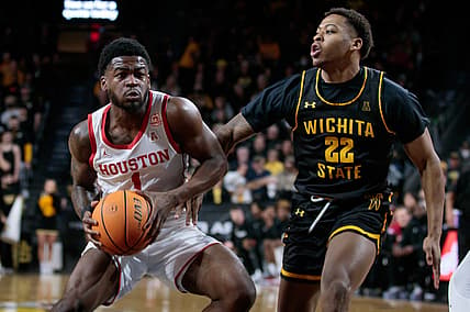 Feb 20, 2022; Wichita, Kansas, USA; Houston Cougars guard Jamal Shead (1) drives to the basket around Wichita State Shockers guard Qua Grant (22) during the first half at Charles Koch Arena. Mandatory Credit: William Purnell-USA TODAY Sports