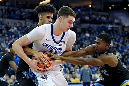 Feb 20, 2022; Omaha, Nebraska, USA;  Marquette Golden Eagles forward Oso Ighodaro (13) and guard Darryl Morsell (32) tie up Creighton Bluejays center Ryan Kalkbrenner (11) in the second half at CHI Health Center Omaha. Mandatory Credit: Steven Branscombe-USA TODAY Sports