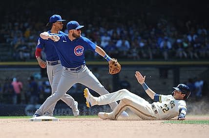 Jul 6, 2022; Milwaukee, Wisconsin, USA; Milwaukee Brewers left fielder Christian Yelich (22) attempts to break up the double play throw of Chicago Cubs third baseman Patrick Wisdom (16) in the fourth inning at American Family Field. Mandatory Credit: Michael McLoone-USA TODAY Sports