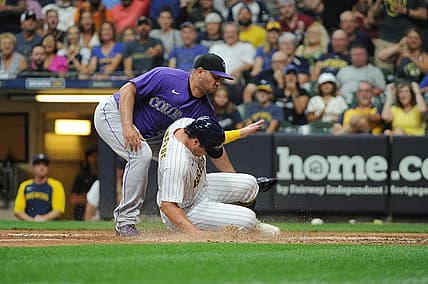 Jul 23, 2022; Milwaukee, Wisconsin, USA; Milwaukee Brewers right fielder Hunter Renfroe (12) scores on a wild pitch as Colorado Rockies relief pitcher Jhoulys Chacin (43) covers the plate in the sixth inning at American Family Field. Mandatory Credit: Michael McLoone-USA TODAY Sports