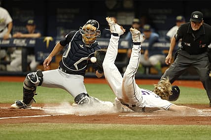 Jul 30, 2022; St. Petersburg, Florida, USA; Tampa Bay Rays shortstop Taylor Walls (6) slides safe into home plate as Cleveland Guardians catcher Luke Maile (12) attempted to tag him out during the second inning at Tropicana Field. Mandatory Credit: Kim Klement-USA TODAY Sports