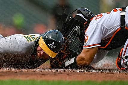 Sep 4, 2022; Baltimore, Maryland, USA;  Oakland Athletics first baseman Seth Brown (15) slides past Baltimore Orioles catcher Robinson Chirinos (23) to score during the second inning at Oriole Park at Camden Yards. Mandatory Credit: Tommy Gilligan-USA TODAY Sports
