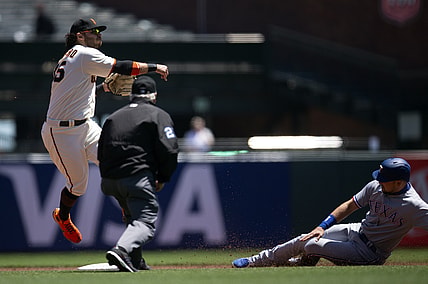 May 11, 2021; San Francisco, California, USA; San Francisco Giants shortstop Brandon Crawford (35) throws over Texas Rangers first baseman Nate Lowe too late to double up Joey Gallo at first base during the first inning at Oracle Park. Texas Rangers shortstop Isiah Kiner-Falefa scored from third on the play. Mandatory Credit: D. Ross Cameron-USA TODAY Sports