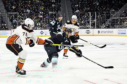 Nov 11, 2021; Seattle, Washington, USA; Seattle Kraken defenseman Mark Giordano (5) clears the puck while being defended by Anaheim Ducks defenseman Josh Mahura (76) during the first period at Climate Pledge Arena. Mandatory Credit: Steven Bisig-USA TODAY Sports