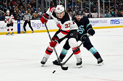 Jan 19, 2023; Seattle, Washington, USA; New Jersey Devils defenseman Ryan Graves (33) protects the puck from Seattle Kraken right wing Oliver Bjorkstrand (22) during the third period at Climate Pledge Arena. Seattle defeated New Jersey 4-3. Mandatory Credit: Steven Bisig-USA TODAY Sports