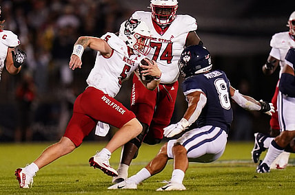 Aug 31, 2023; East Hartford, Connecticut, USA; North Carolina State Wolfpack quarterback Brennan Armstrong (5) runs the ball against UConn Huskies linebacker Jackson Mitchell (8) in the second quarter at Rentschler Field at Pratt & Whitney Stadium. Mandatory Credit: David Butler II-USA TODAY Sports