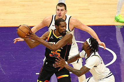 Dec 1, 2023; Phoenix, Arizona, USA; Phoenix Suns forward Kevin Durant (35) controls the ball under pressure from Denver Nuggets guard Kentavious Caldwell-Pope (5) and center Nikola Jokic (15) in the second half at Footprint Center. Mandatory Credit: Mark J. Rebilas-USA TODAY Sports