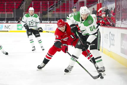 Jan 31, 2021; Raleigh, North Carolina, USA;  Dallas Stars center Tanner Kero (64) tries to control the puck against Carolina Hurricanes center Steven Lorentz (78) at PNC Arena. Mandatory Credit: James Guillory-USA TODAY Sports