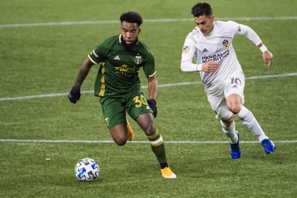 Oct 28, 2020; Portland, Oregon, USA; Portland Timbers midfielder Eryk Williamson (30) pushes past Los Angeles Galaxy forward Cristian Pavon (10) during the first half at Providence Park.  Mandatory Credit: Troy Wayrynen-USA TODAY Sports