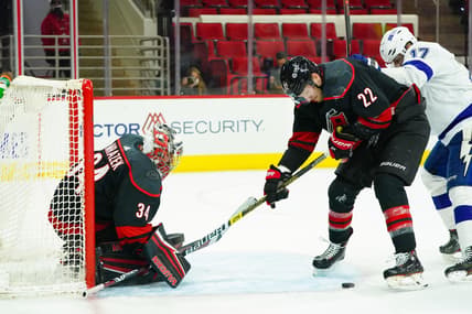 Jan 28, 2021; Raleigh, North Carolina, USA;  Carolina Hurricanes goaltender Petr Mrazek (34) and defenseman Brett Pesce (22) watch the puck against the Tampa Bay Lightning at PNC Arena. Mandatory Credit: James Guillory-USA TODAY Sports
