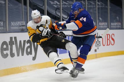 Feb 6, 2021; Uniondale, New York, USA; New York Islanders defenseman Scott Mayfield (24) checks Pittsburgh Penguins center Evgeni Malkin (71) during the first period at Nassau Veterans Memorial Coliseum. Mandatory Credit: Brad Penner-USA TODAY Sports