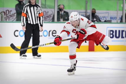 Feb 13, 2021; Dallas, Texas, USA; Carolina Hurricanes defenseman Brett Pesce (22) shoots the puck in the Dallas Stars zone during the third period at the American Airlines Center. Mandatory Credit: Jerome Miron-USA TODAY Sports