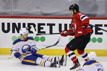 Feb 23, 2021; Newark, New Jersey, USA; New Jersey Devils defenseman Damon Severson (28) plays the puck against Buffalo Sabres center Rasmus Asplund (74) during the third period at Prudential Center. Mandatory Credit: Vincent Carchietta-USA TODAY Sports