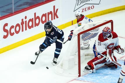 Mar 15, 2021; Winnipeg, Manitoba, CAN; Winnipeg Jets forward Matthieu Perreault (85) skates away from Montreal Canadiens defenseman Alexander Romanov (27) during the third period at Bell MTS Place. Mandatory Credit: Terrence Lee-USA TODAY Sports
