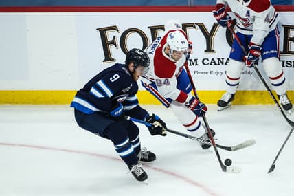 Mar 15, 2021; Winnipeg, Manitoba, CAN; Montreal Canadiens forward Corey Perry (94) battles Winnipeg Jets forward Andrew Copp (9) for the puck during the first period at MTS Place. Mandatory Credit: Terrence Lee-USA TODAY Sports