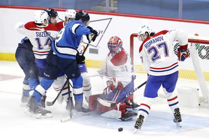 Mar 17, 2021; Winnipeg, Manitoba, CAN; Montreal Canadiens goaltender Carey Price (31) watches the puck as Winnipeg Jets center Andrew Copp (9) and defenseman Alexander Romanov (27) try for a rebound in the second period at Bell MTS Place. Mandatory Credit: James Carey Lauder-USA TODAY Sports