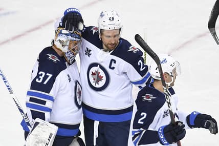 Mar 29, 2021; Calgary, Alberta, CAN; Winnipeg Jets goalie Connor Hellebuyck (37) celebrates with forward Blake Wheeler (26) after a victory over the Calgary Flames at Scotiabank Saddledome. Mandatory Credit: Candice Ward-USA TODAY Sports
