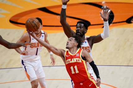 Mar 30, 2021; Phoenix, Arizona, USA; Atlanta Hawks guard Trae Young (11) shoots a layup against Phoenix Suns center Deandre Ayton (22) during the first half at Phoenix Suns Arena. Mandatory Credit: Joe Camporeale-USA TODAY Sports