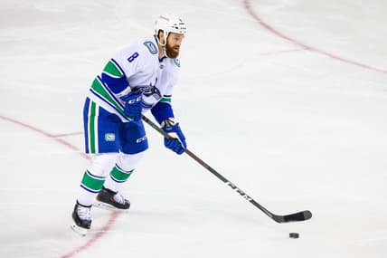 Feb 17, 2021; Calgary, Alberta, CAN; Vancouver Canucks defenseman Jordie Benn (8) controls the puck against the Calgary Flames during the first period at Scotiabank Saddledome. Mandatory Credit: Sergei Belski-USA TODAY Sports
