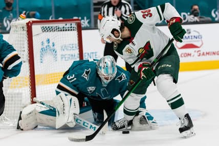 Mar 31, 2021; San Jose, California, USA; San Jose Sharks goaltender Martin Jones (31) battles for the puck with Minnesota Wild right wing Ryan Hartman (38) during the first period at SAP Center at San Jose. Mandatory Credit: John Hefti-USA TODAY Sports