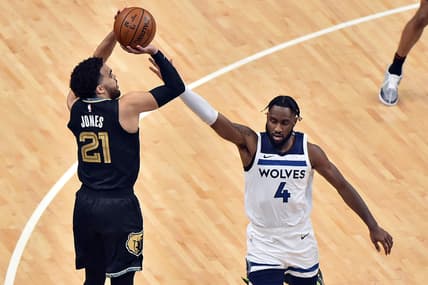 Apr 2, 2021; Memphis, Tennessee, USA;  Memphis Grizzlies guard Tyus Jones (21) shoots against Minnesota Timberwolves guard Jaylen Nowell (4) during the first half at FedExForum. Mandatory Credit: Justin Ford-USA TODAY Sports
