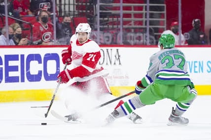 Apr 10, 2021; Raleigh, North Carolina, USA;  Detroit Red Wings center Dylan Larkin (71) tries to control the puck against Carolina Hurricanes right wing Andrei Svechnikov (37) at PNC Arena. Mandatory Credit: James Guillory-USA TODAY Sports
