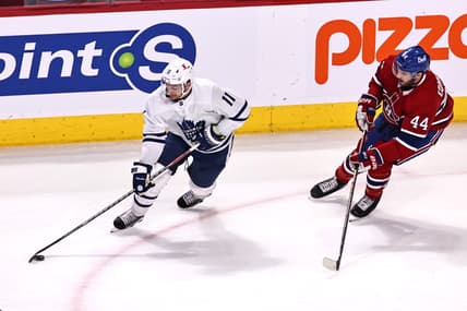 Apr 12, 2021; Montreal, Quebec, CAN; Toronto Maple Leafs left wing Zach Hyman (11) plays the puck against Montreal Canadiens defenseman Joel Edmundson (44) during the first period at Bell Centre. Mandatory Credit: Jean-Yves Ahern-USA TODAY Sports