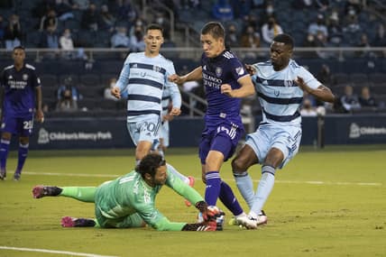 Apr 23, 2021; Kansas City, Kansas, USA; Sporting Kansas City goalkeeper John Pulskamp (1) blocks a shot by Orlando City defender Rodrigo Schlegel (15) at Children's Mercy Park. Mandatory Credit: Amy Kontras-USA TODAY Sports