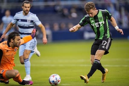 May 9, 2021; Kansas City, Kansas, USA; Austin FC forward Jon Gallagher (17) scores a goal past Sporting Kansas City goalkeeper John Pulskamp (1) at Children's Mercy Park. Mandatory Credit: Jay Biggerstaff-USA TODAY Sports