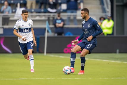 May 16, 2021; Kansas City, Kansas, USA;  Sporting Kansas City forward Khiry Shelton (11) passes against Vancouver Whitecaps defender Cristian Gutierrez (3) during the first half at Children's Mercy Park. Mandatory Credit: William Purnell-USA TODAY Sports