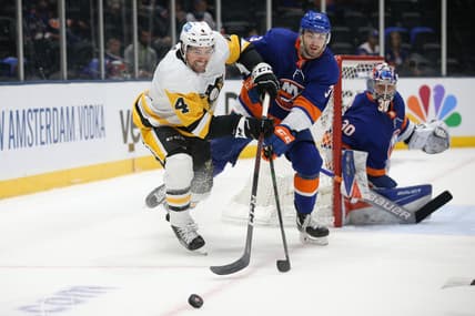 May 22, 2021; Uniondale, New York, USA; Pittsburgh Penguins defenseman Cody Ceci (4) and New York Islanders defenseman Adam Pelech (3) fight for the puck during the first period of game four of the first round of the 2021 Stanley Cup Playoffs at Nassau Veterans Memorial Coliseum. Mandatory Credit: Brad Penner-USA TODAY Sports