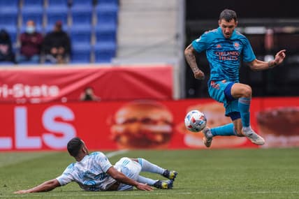 May 29, 2021; Harrison, New Jersey, USA; Orlando City SC defender Kyle Smith (24) plays the ball against New York Red Bulls midfielder Cristian Casseres Jr (23) during the first half at Red Bull Arena. Mandatory Credit: Vincent Carchietta-USA TODAY Sports