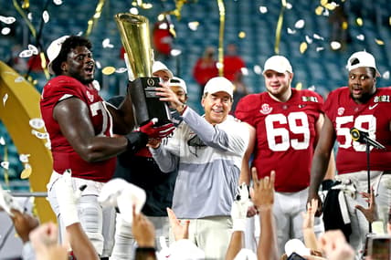 Jan 11, 2021; Miami Gardens, Florida, USA; Alabama Crimson Tide head coach Nick Saban and offensive lineman Alex Leatherwood (70) celebrates with the CFP National Championship trophy after beating the Ohio State Buckeyes in the 2021 College Football Playoff National Championship Game. Mandatory Credit: Mark J. Rebilas-USA TODAY Sports