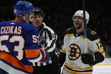 Jun 3, 2021; Uniondale, New York, USA; Boston Bruins right wing Craig Smith (12) yells at New York Islanders center Casey Cizikas (53) as the two are separated by linesman Mark Shewchyk (92) during the second period of game three of the second round of the 2021 Stanley Cup Playoffs at Nassau Veterans Memorial Coliseum. Mandatory Credit: Brad Penner-USA TODAY Sports