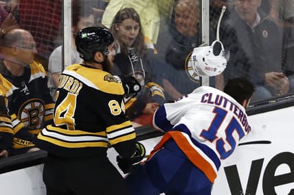 Jun 7, 2021; Boston, Massachusetts, USA; Boston Bruins defenseman Jarred Tinordi (84) knocks the helmet off of New York Islanders right wing Cal Clutterbuck (15) with a check along the boards during the first period of game five of the second round of the 2021 Stanley Cup Playoffs at TD Garden. Mandatory Credit: Winslow Townson-USA TODAY Sports