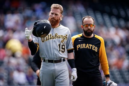 Jun 28, 2021; Denver, Colorado, USA; Pittsburgh Pirates first baseman Colin Moran (19) walks to first with strength and conditioning coach Terence Brannic after being hit by a pitch in the first inning Colorado Rockies at Coors Field. Mandatory Credit: Isaiah J. Downing-USA TODAY Sports