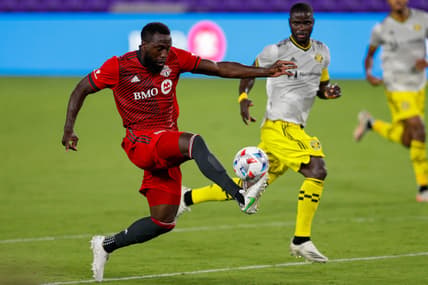 May 12, 2021; Orlando, Florida, CAN; Toronto FC forward Jozy Altidore (17) receives a pass while defended by  Columbus Crew FC defender Jonathan Mensah (4) during the second half at Orlando City Stadium. Mandatory Credit: Nathan Ray Seebeck-USA TODAY Sports