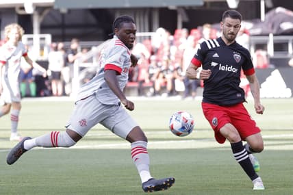 Jul 3, 2021; Washington, DC, USA; Toronto FC forward Ayo Akinola (20) shoots the ball as D.C. United defender Brendan Hines-Ike (4) defends in the first half at Audi Field. Mandatory Credit: Geoff Burke-USA TODAY Sports