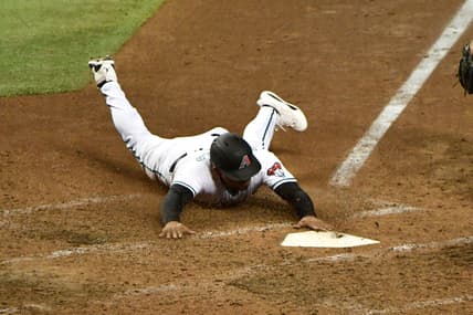 Jul 20, 2021; Phoenix, Arizona, USA;  Arizona Diamondbacks third baseman Eduardo Escobar (5) slides into home plate to score in the sixth inning against the Pittsburgh Pirates at Chase Field. Mandatory Credit: Matt Kartozian-USA TODAY Sports