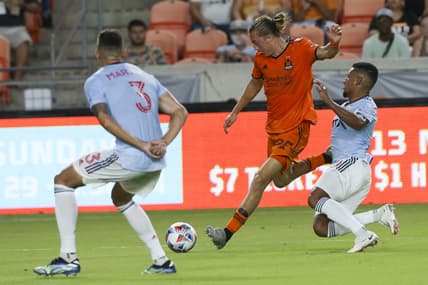 Aug 21, 2021; Houston, Texas, USA; Houston Dynamo midfielder Griffin Dorsey (25) splits the FC Dallas midfielder Bryan Acosta (8) and defender Jose Antonio Martinez (3)in the first half at BBVA Compass Stadium. Mandatory Credit: Thomas Shea-USA TODAY Sports