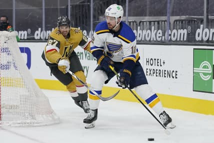 Mar 22, 2021; Las Vegas, Nevada, USA; St. Louis Blues left wing Zach Sanford (12) passes the puck around Vegas Golden Knights defenseman Shea Theodore (27) during the first period at T-Mobile Arena. Mandatory Credit: John Locher /POOL PHOTOS-USA TODAY Sports