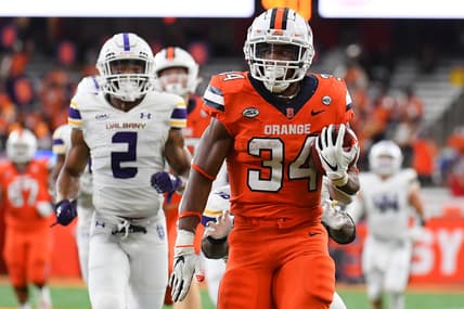 Sep 18, 2021; Syracuse, New York, USA; Syracuse Orange running back Sean Tucker (34) runs with the ball in front of Albany Great Danes defensive back Tyler Carswell (2) on his way to the end zone for a touchdown during the first half at the Carrier Dome. Mandatory Credit: Rich Barnes-USA TODAY Sports