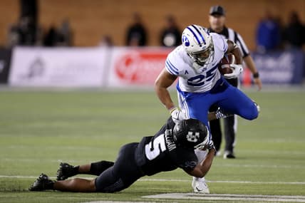 Oct 1, 2021; Logan, Utah, USA; Utah State Aggies linebacker Cash Gilliam (5) tackles Brigham Young Cougars running back Tyler Allgeier (25) during the third quarter at Merlin Olsen Field at Maverik Stadium. Mandatory Credit: Rob Gray-USA TODAY Sports