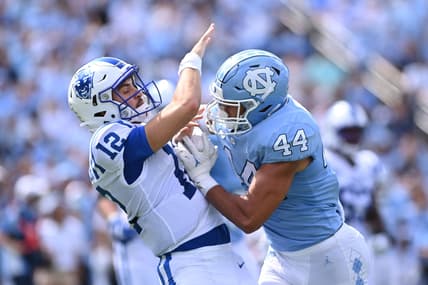 Oct 2, 2021; Chapel Hill, North Carolina, USA; Duke Blue Devils quarterback Gunnar Holmberg (12) is hit by North Carolina Tar Heels linebacker Jeremiah Gemmel (44) as he passes the ball in the second quarter at Kenan Memorial Stadium. Mandatory Credit: Bob Donnan-USA TODAY Sports