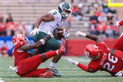 Oct 9, 2021; Piscataway, New Jersey, USA; Michigan State Spartans running back Kenneth Walker III (9) is tackled by Rutgers Scarlet Knights defensive back Avery Young (2) and defensive lineman CJ Onyechi (26) during the second half at SHI Stadium. Mandatory Credit: Vincent Carchietta-USA TODAY Sports