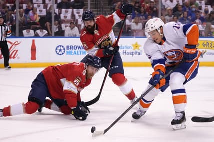Oct 16, 2021; Sunrise, Florida, USA; New York Islanders center Mathew Barzal (13) shoots the puck in front of Florida Panthers center Sam Bennett (9) and defenseman Radko Gudas (7) during the first period at FLA Live Arena. Mandatory Credit: Jasen Vinlove-USA TODAY Sports