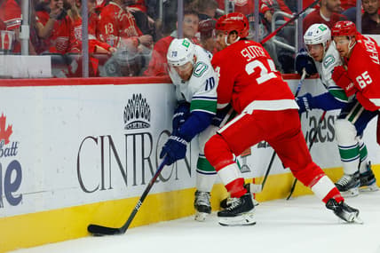 Oct 16, 2021; Detroit, Michigan, USA;  Vancouver Canucks left wing Tanner Pearson (70) is checked by Detroit Red Wings center Pius Suter (24) in the first period at Little Caesars Arena. Mandatory Credit: Rick Osentoski-USA TODAY Sports