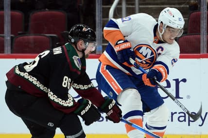 Oct 23, 2021; Glendale, Arizona, USA; New York Islanders center Anders Lee (27) shoots the puck against Arizona Coyotes defenseman Anton Stralman (86) during the first period at Gila River Arena. Mandatory Credit: Joe Camporeale-USA TODAY Sports